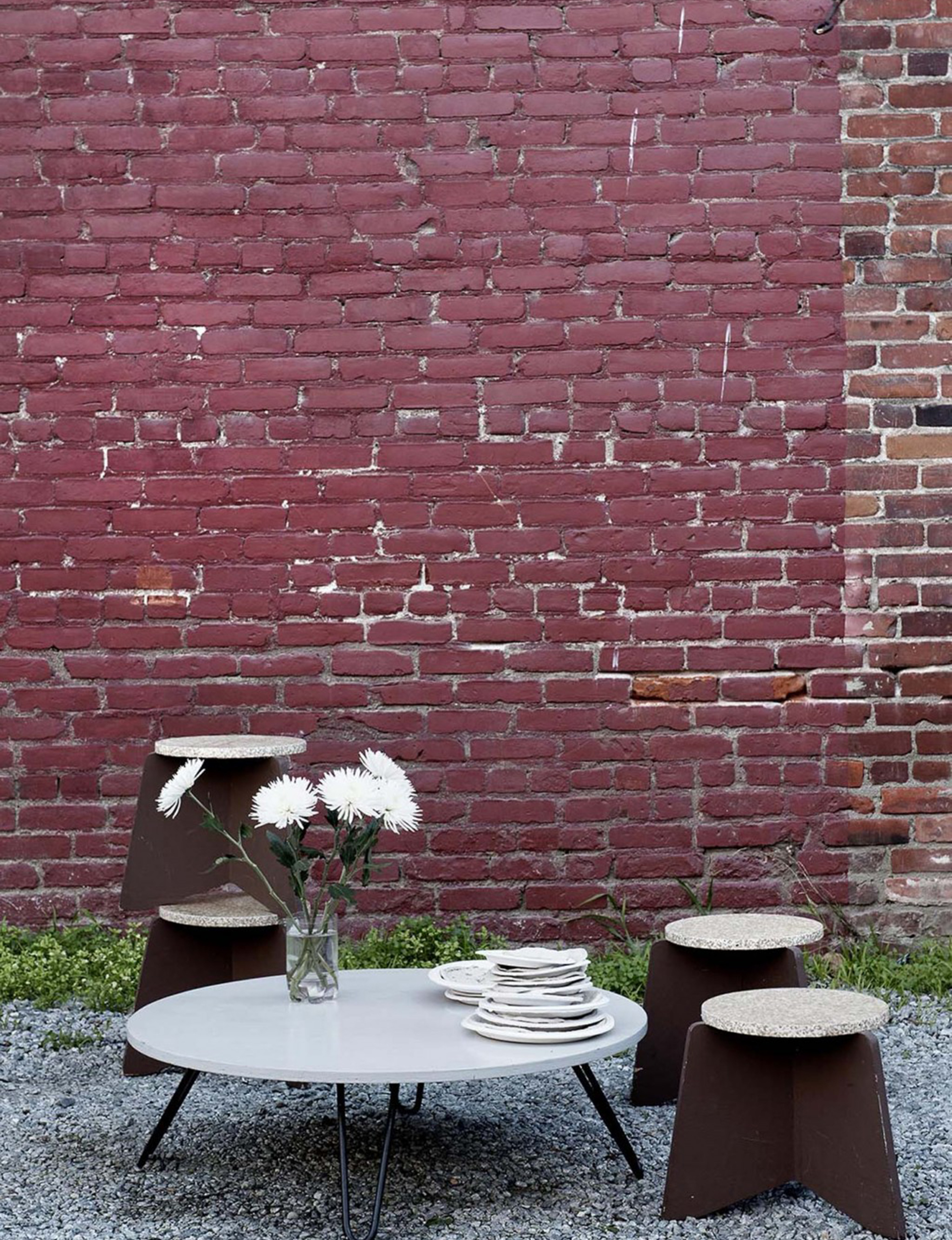 A reproduction of Richard Neutra's studio table and stools made by Connor are set up in the back yard.