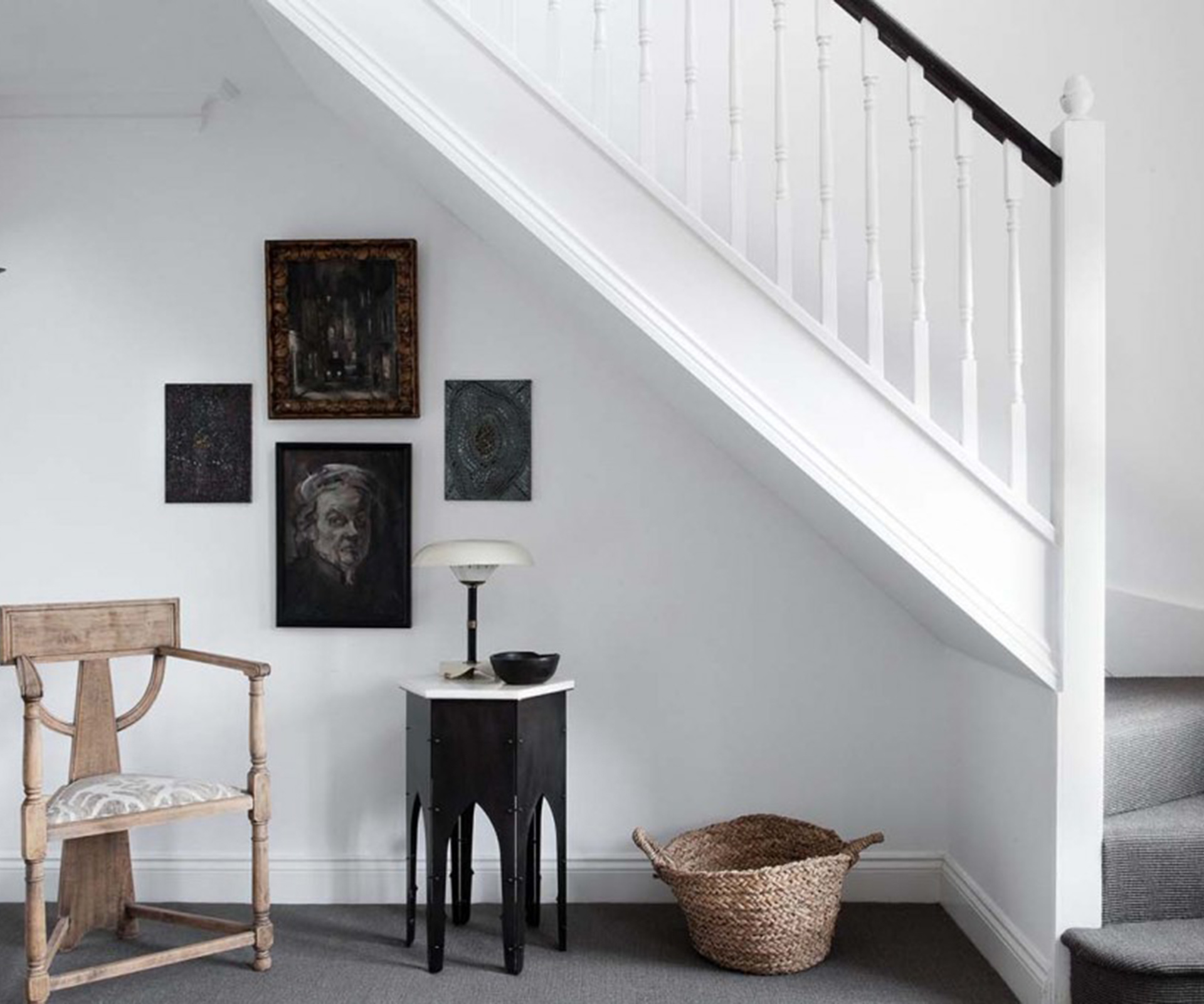 A chair, table and lamp of Hall's own design sit under the stairs; Hall also designed the wall lamp. The four artworks are Parisian flea-market finds. 