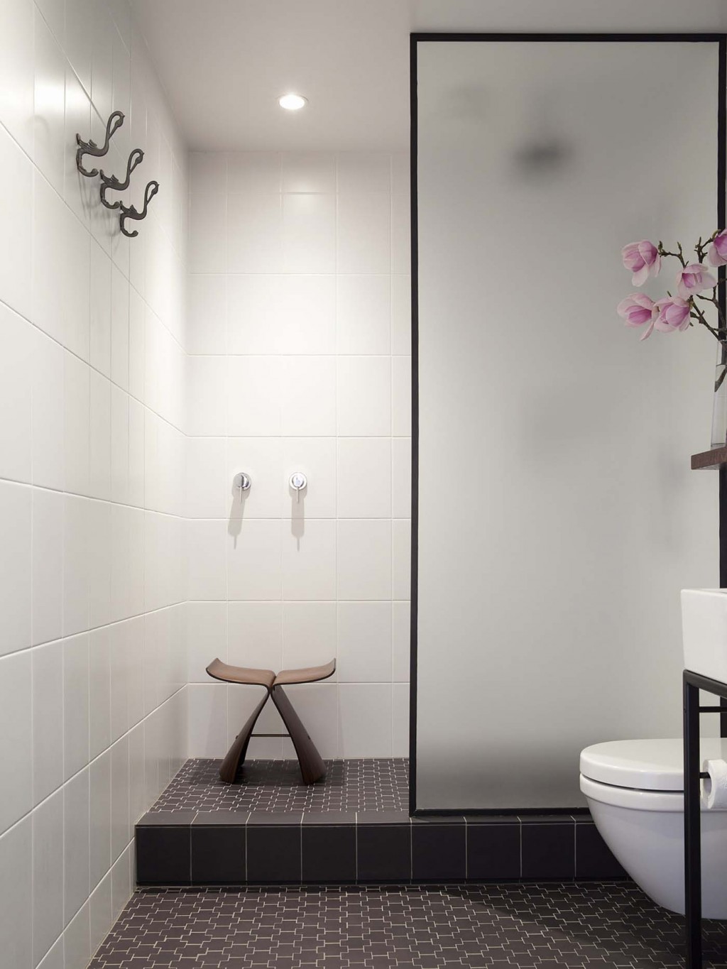 The bathroom - a windowless space in Carroll's small apartment - now features Deco-flavoured floor tiles and a simple shower area. Photograph by David Straight. 