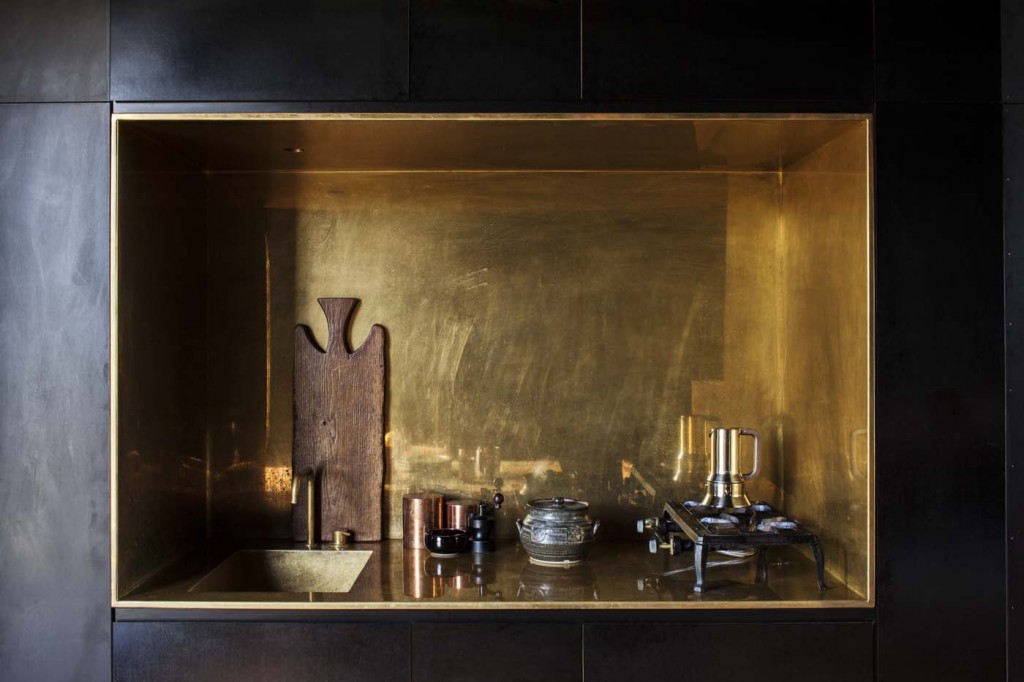 In the black cabin, the kitchen is a small brass inset. Photograph by Darryl Ward. 