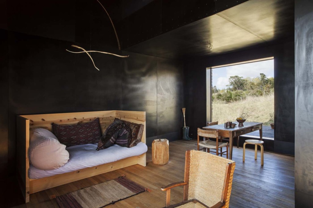 Inside the black cabin, the daybed is by Donald Judd and the twig mobile by Eleanor Cooper. The sleeping loft is on the mezzanine floor above this space. Photograph by Darryl Ward. 