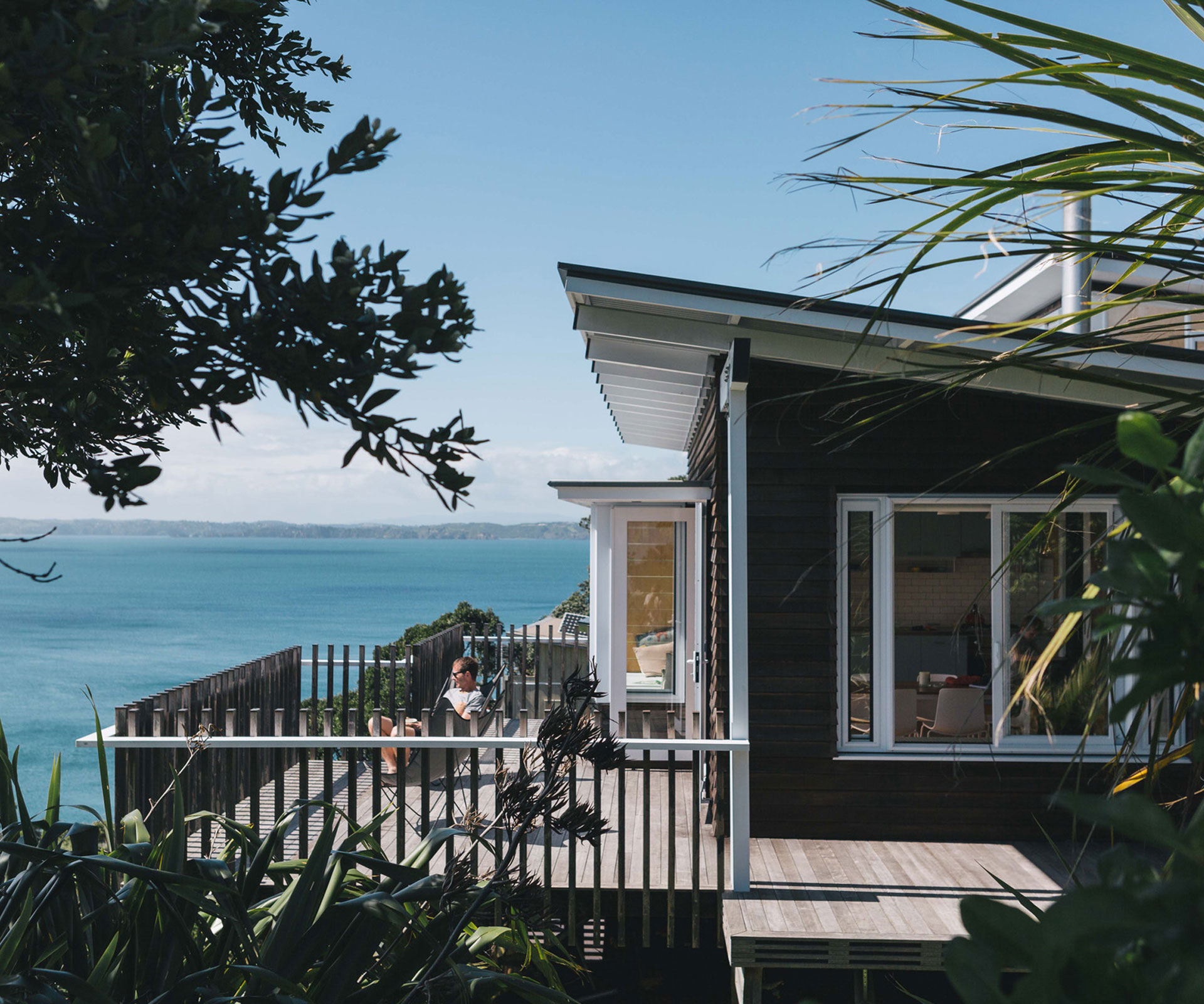 The Rakino Island bach by Malcolm Walker opens onto a large deck with sea views.