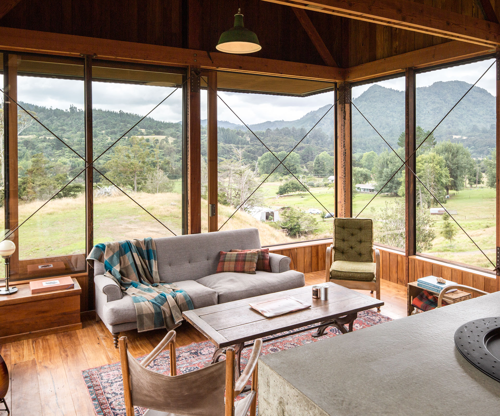  The home's living room is surrounded by glass, and topped by a double-height volume lined in recycled rimu.