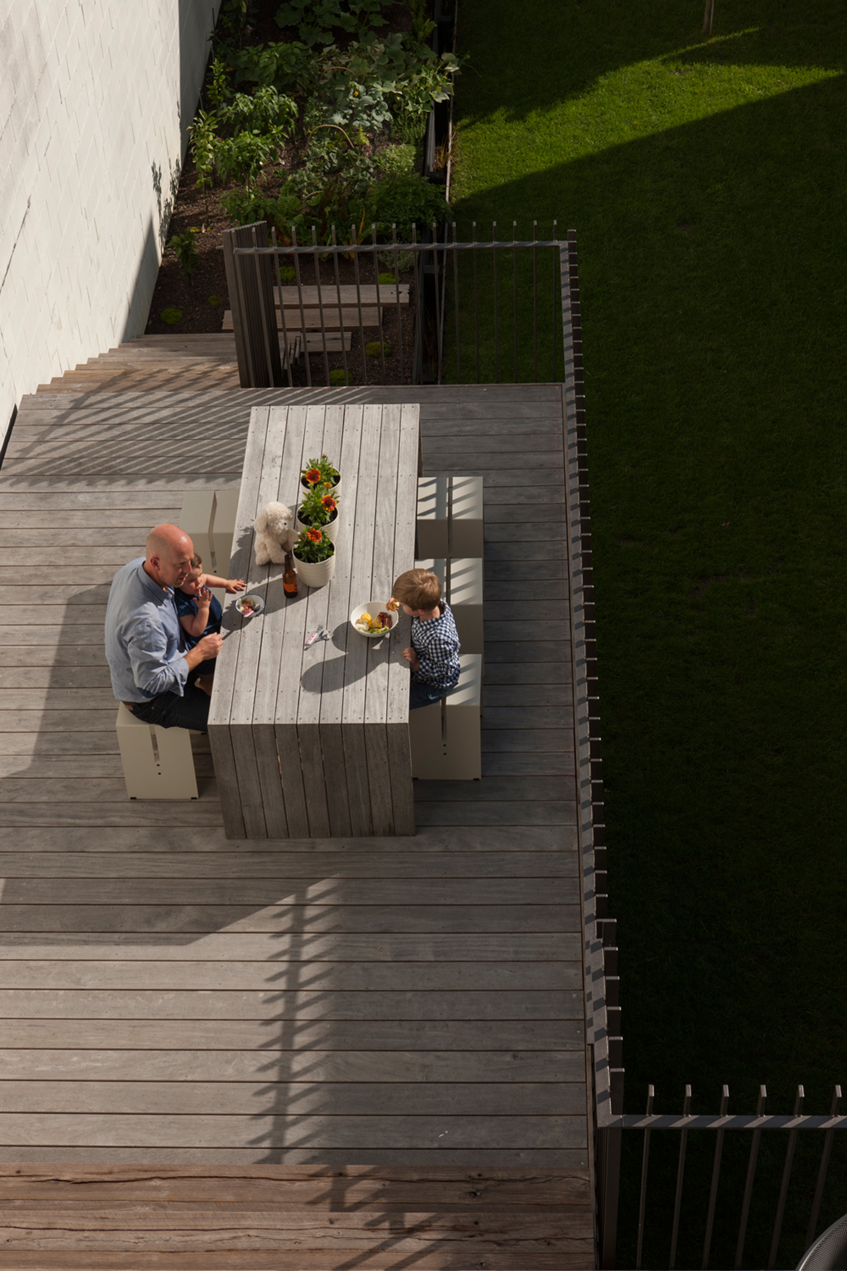 The sunny terrace has steps leading to the back lawn. 