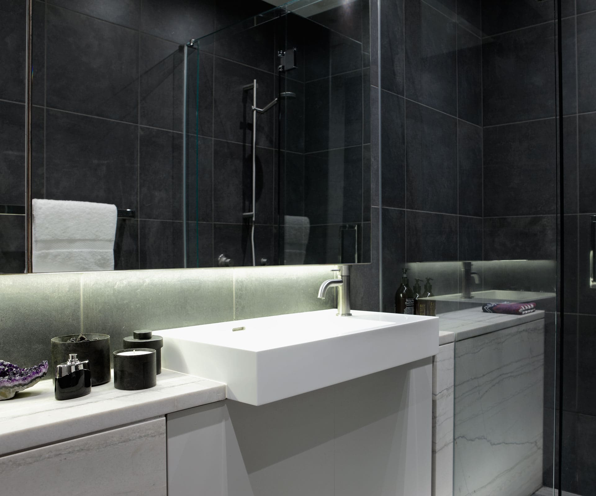 These windowless bathrooms embraced the dark by choosing black tiles