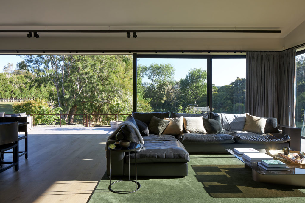 Interior view of the house: leather couches with a lot of sun and views of the garden